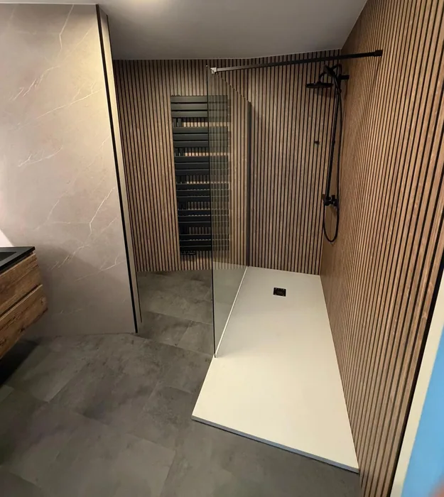 Badkamer met inloopdouche, witte douchebak, lamellenwand en marmerlook panelen